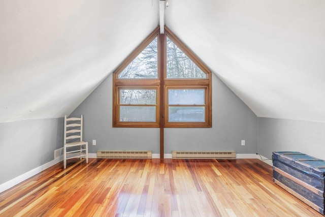 bonus room featuring light wood-type flooring, baseboards, a baseboard radiator, lofted ceiling, and baseboard heating