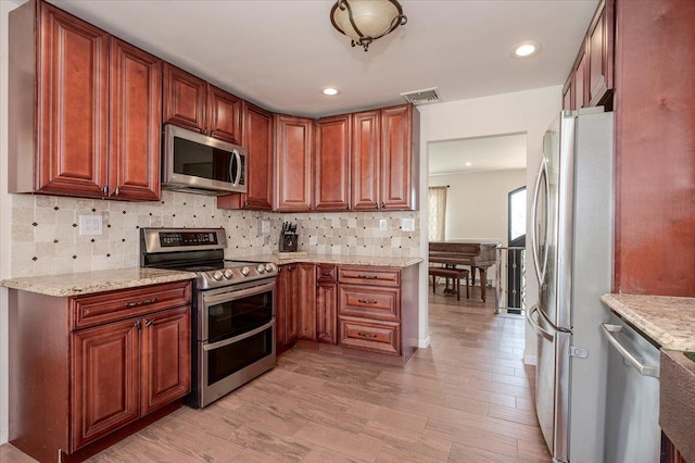 101 Jetmore Pl, Massapequa, NY 11758 - kitchen featuring light stone counters, light wood finished floors, backsplash, and stainless steel appliances