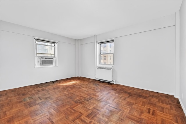 unfurnished room featuring cooling unit and radiator