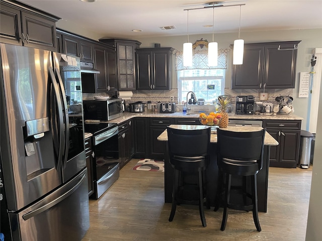 kitchen featuring appliances with stainless steel finishes, backsplash, visible vents, and under cabinet range hood