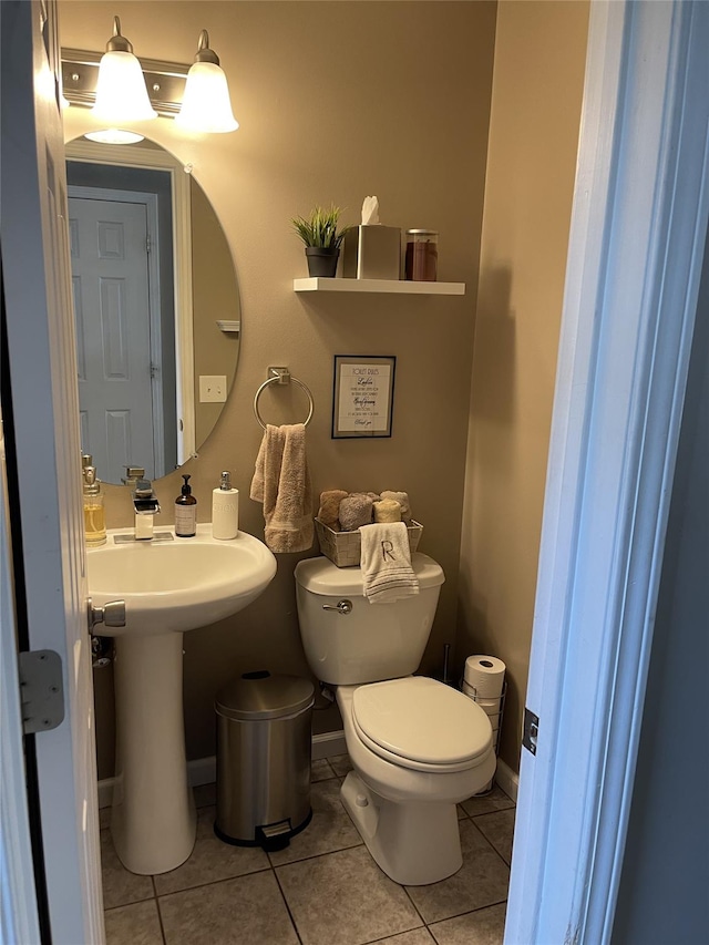 bathroom with tile patterned flooring, baseboards, and toilet