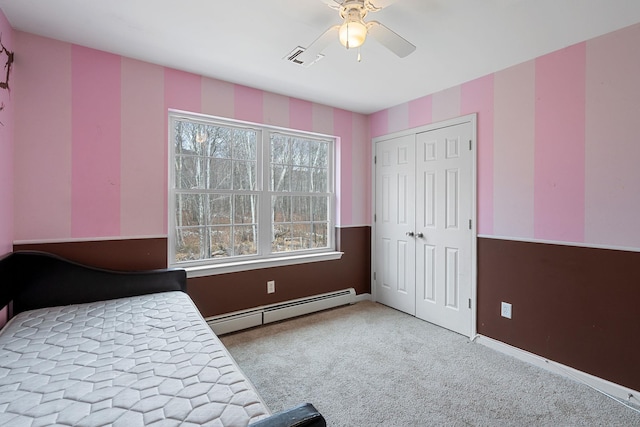 carpeted bedroom featuring visible vents, baseboards, ceiling fan, a closet, and baseboard heating