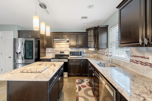 kitchen with visible vents, a sink, stainless steel appliances, under cabinet range hood, and light wood-type flooring