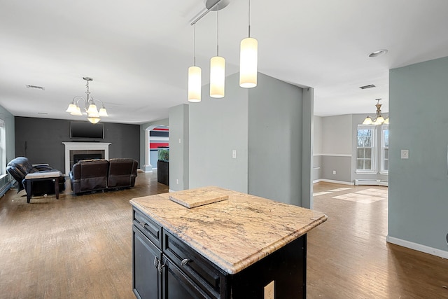 kitchen featuring wood finished floors, open floor plan, and a chandelier