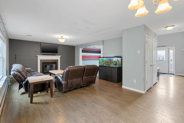 living room with baseboards, arched walkways, wood finished floors, and a fireplace