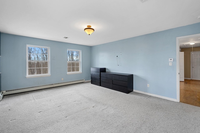 unfurnished bedroom featuring visible vents, carpet floors, baseboard heating, and attic access