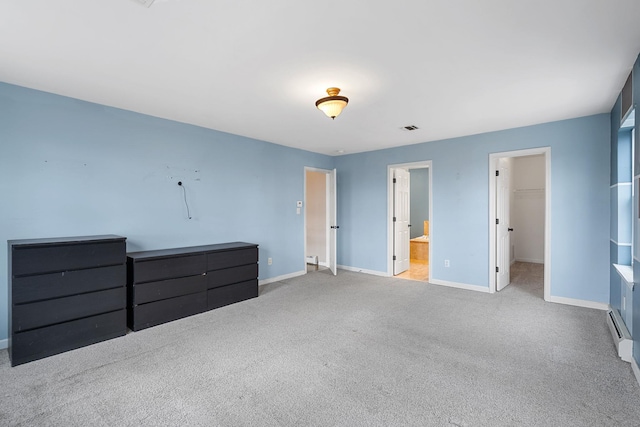 unfurnished bedroom featuring a spacious closet, visible vents, carpet flooring, and baseboards
