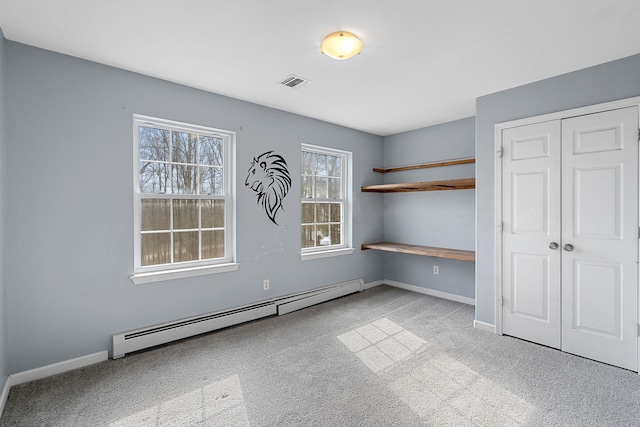 unfurnished bedroom featuring visible vents, baseboards, baseboard heating, and a closet