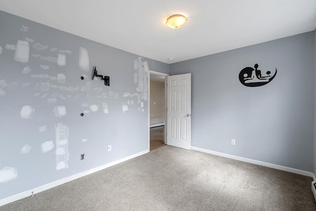 unfurnished room featuring baseboards, carpet, and a baseboard radiator
