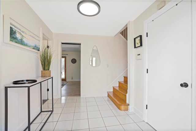 foyer featuring light tile patterned flooring and stairs