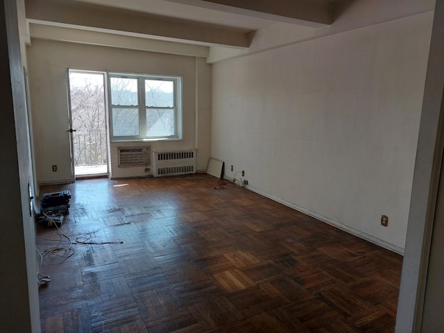 empty room featuring beamed ceiling and radiator heating unit