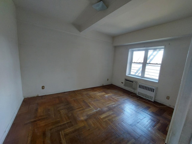 empty room with beam ceiling and a wall mounted air conditioner