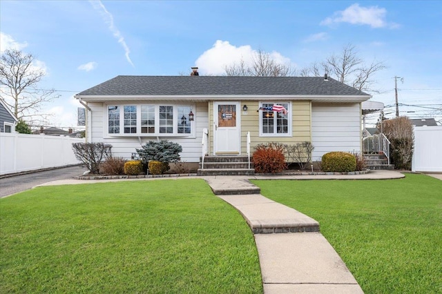 view of front facade featuring roof with shingles, fence, a chimney, and a front lawn