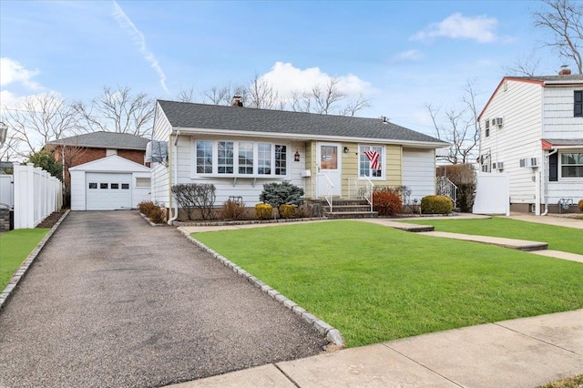 view of front facade with an outbuilding, a front yard, fence, a garage, and driveway