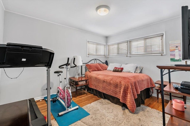 bedroom featuring baseboards and wood finished floors