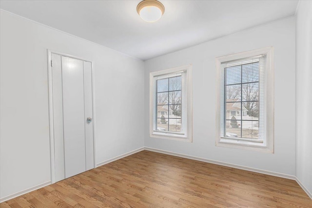 unfurnished room featuring light wood finished floors and baseboards