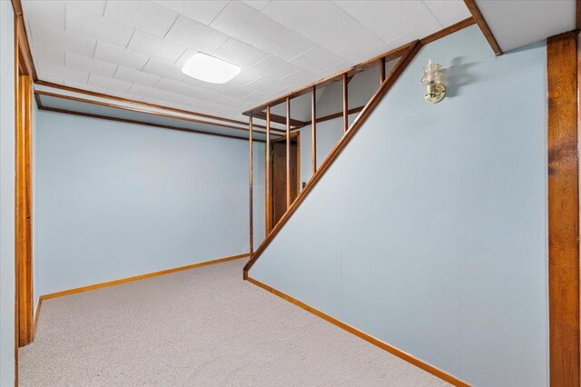 finished basement with carpet, baseboards, and stairs