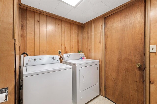 laundry area with laundry area, washing machine and dryer, and wooden walls