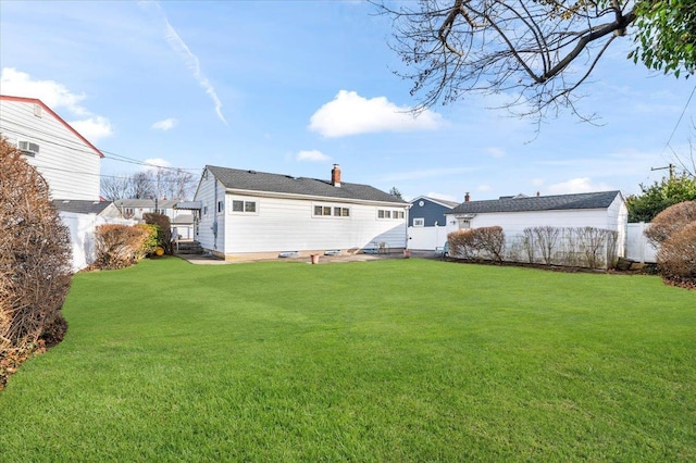 back of property featuring a fenced backyard, a chimney, and a yard