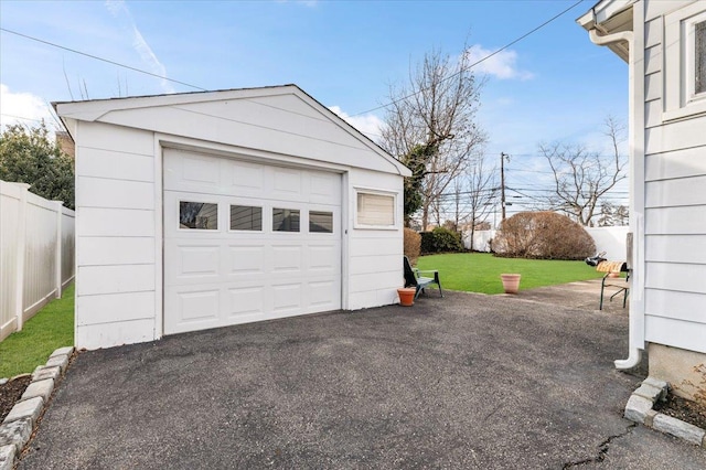 detached garage with driveway and fence