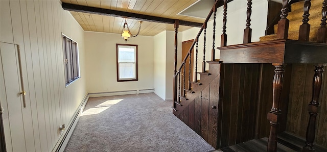 corridor with stairway, carpet flooring, beamed ceiling, and wood walls