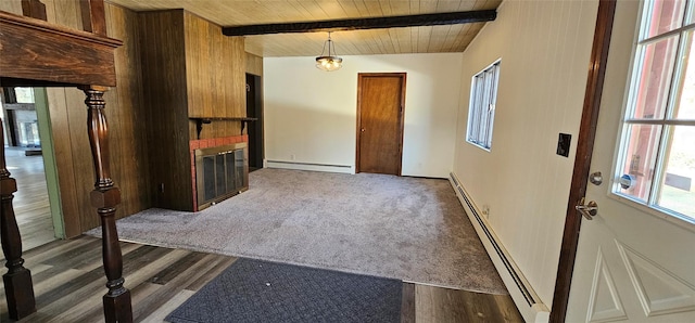 empty room with beam ceiling, wooden ceiling, a fireplace, and baseboard heating