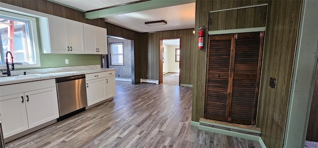 kitchen featuring a baseboard heating unit, a healthy amount of sunlight, a sink, and stainless steel dishwasher