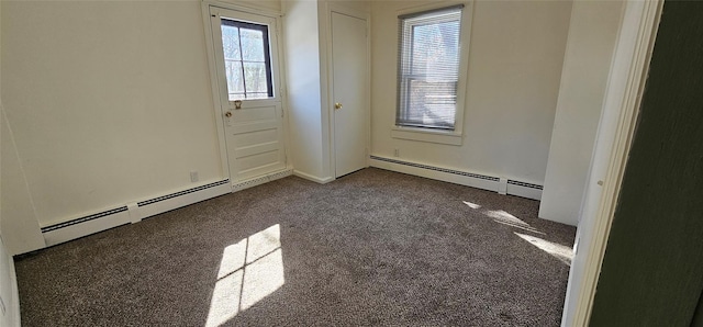 empty room with baseboard heating and dark colored carpet