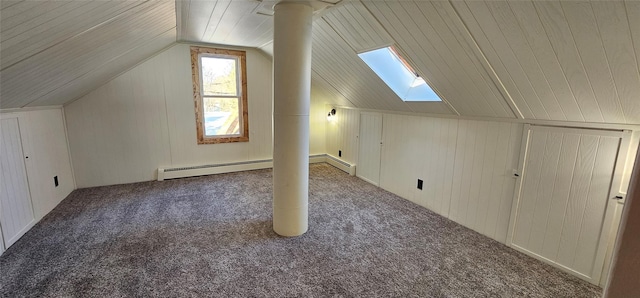 bonus room with carpet floors, vaulted ceiling with skylight, wooden walls, and baseboard heating