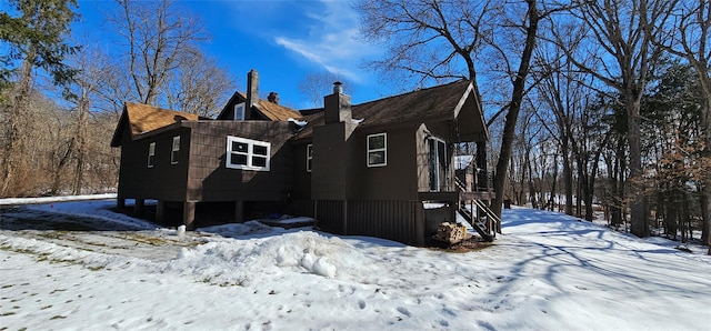 snow covered property featuring a chimney