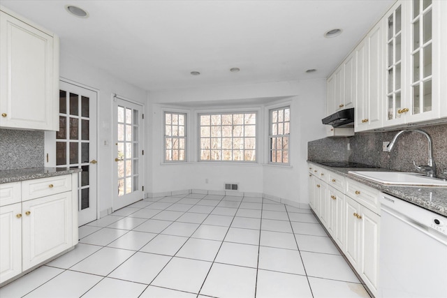 kitchen featuring light tile patterned floors, visible vents, a sink, dishwasher, and under cabinet range hood