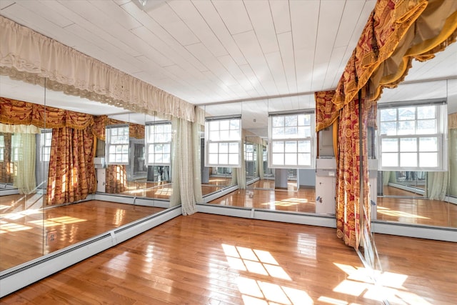 unfurnished sunroom featuring wood ceiling and baseboard heating