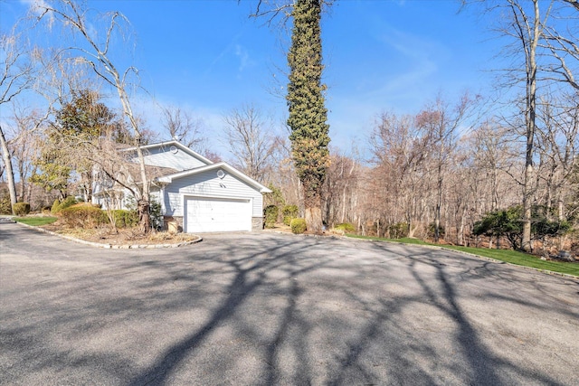 view of side of home featuring an attached garage and driveway