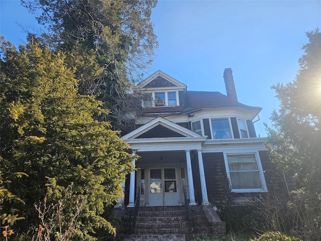 view of front of home with covered porch and a chimney