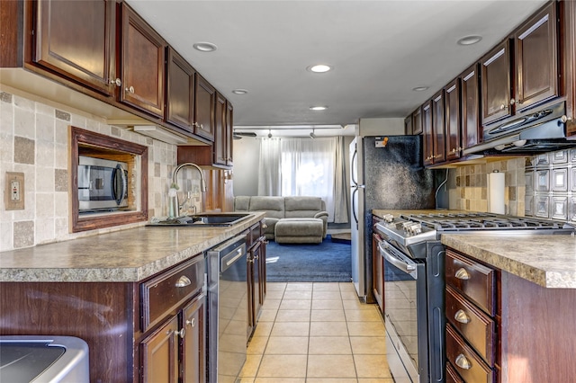 kitchen with backsplash, appliances with stainless steel finishes, open floor plan, light tile patterned flooring, and a sink