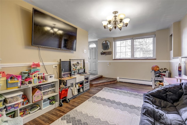 living room featuring a baseboard heating unit, a notable chandelier, and wood finished floors