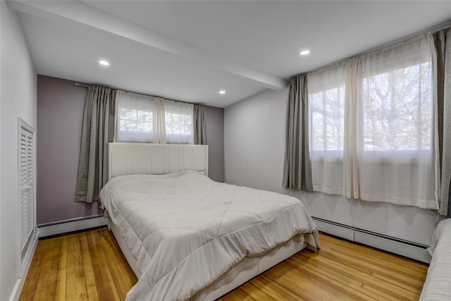 bedroom featuring baseboard heating, wood finished floors, and recessed lighting