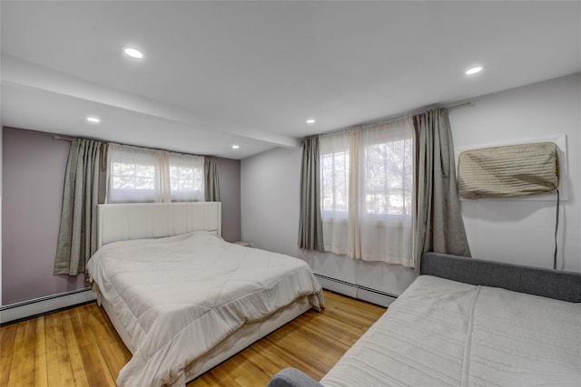 bedroom featuring recessed lighting, baseboard heating, and wood finished floors