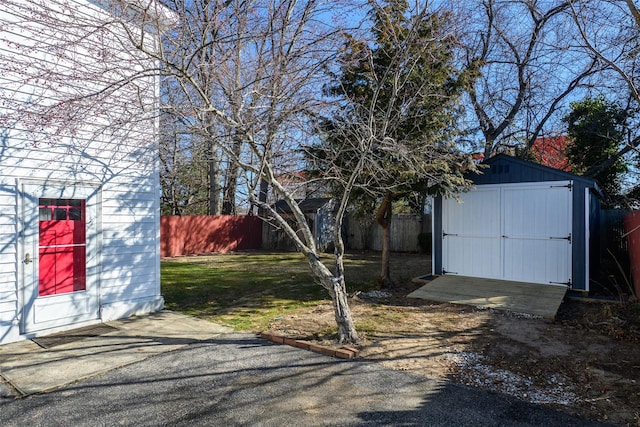 view of yard featuring a fenced backyard, an outdoor structure, and a storage unit