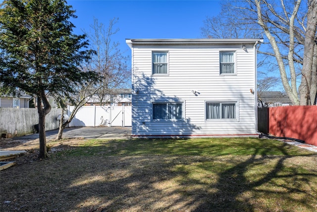 rear view of house with a yard, a patio area, and a fenced backyard