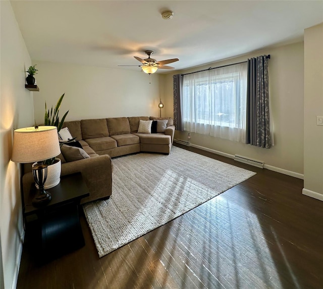 living area featuring dark wood-type flooring, baseboards, and ceiling fan