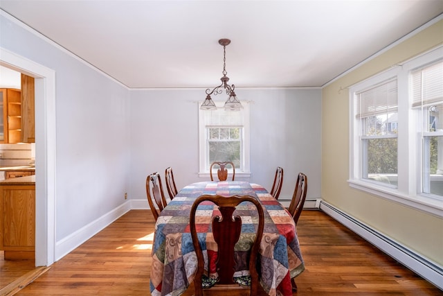 dining area featuring a baseboard radiator, crown molding, and light wood-style flooring