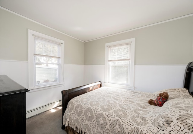 carpeted bedroom with a wainscoted wall, ornamental molding, and baseboard heating