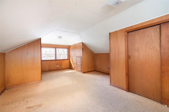 additional living space with lofted ceiling, wood walls, and carpet floors