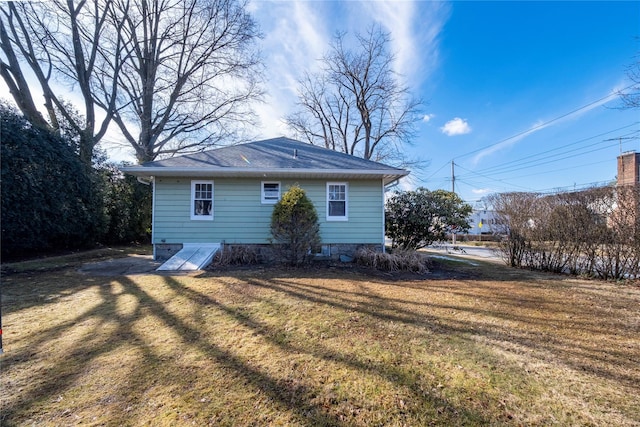 rear view of property featuring a lawn