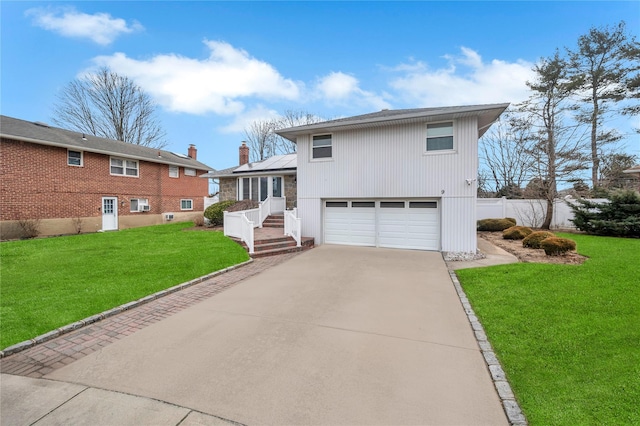 tri-level home featuring a garage, fence, concrete driveway, and a front yard