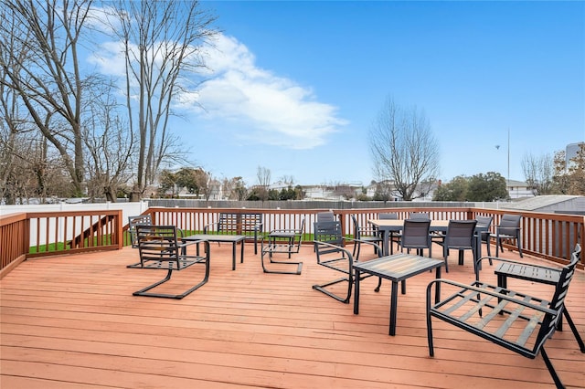 wooden terrace with outdoor dining space and fence