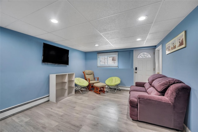 living area with a paneled ceiling, recessed lighting, wood finished floors, baseboards, and baseboard heating