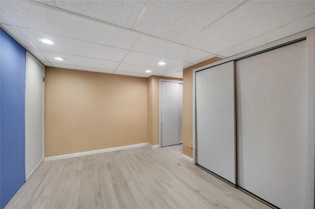 interior space featuring recessed lighting, a drop ceiling, light wood-style flooring, and baseboards