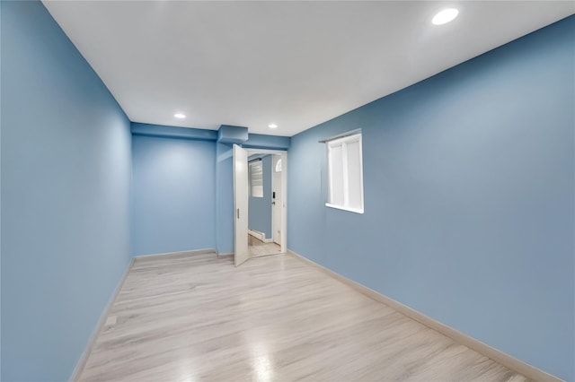 spare room featuring baseboards, wood finished floors, and recessed lighting